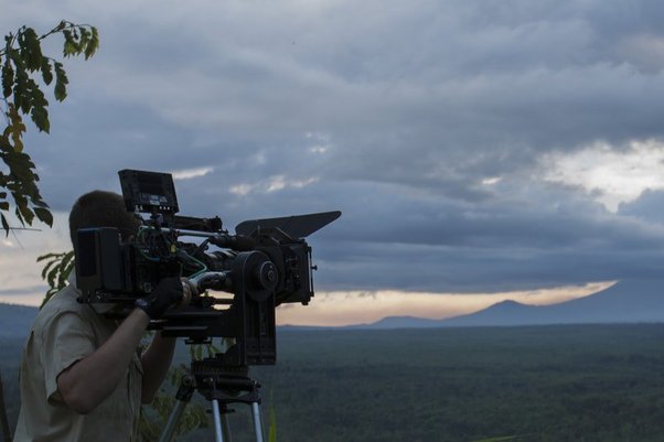 Still from Virunga, showing documentart filming African landscape with film camera, direced by Orlando von Einsiedel (2014)