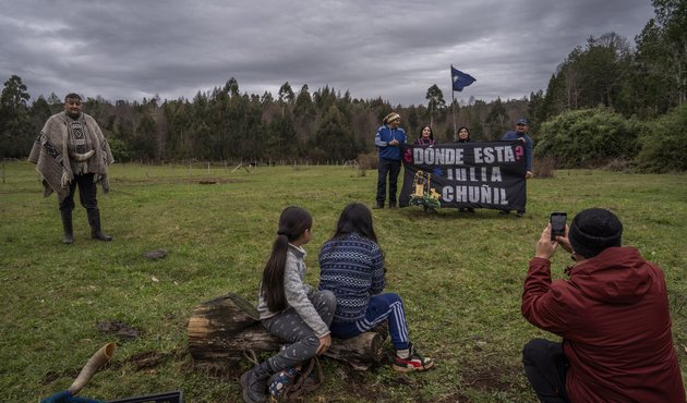 Family members and friends of Julia Chuñil display a banner that reads: “Where is Julia Chuñil?” on the land where she was last seen