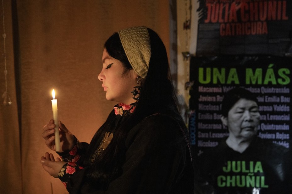 Lissette Sánchez lights a candle to honour her grandmother, Julia Chuñil, a Mapuche defender who has been missing since November 2024.