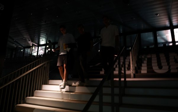People use their phone torch to walk through the dark gangways during a general power blackout during Day Seven of the Mutua Madrid Open at La Caja Magica on April 28, 2025 in Madrid, Spain.
